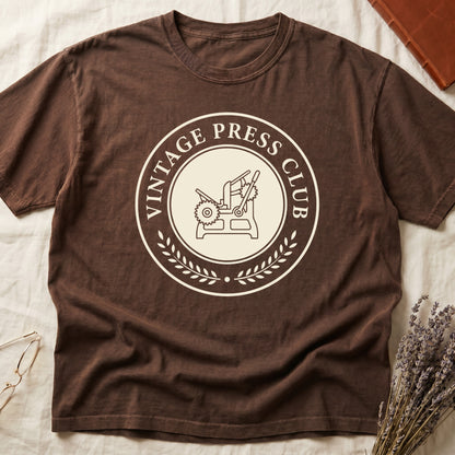 Espresso tee with circular letterpress badge, "VINTAGE PRESS CLUB" in serif capitals, antique printing press in cream linework.