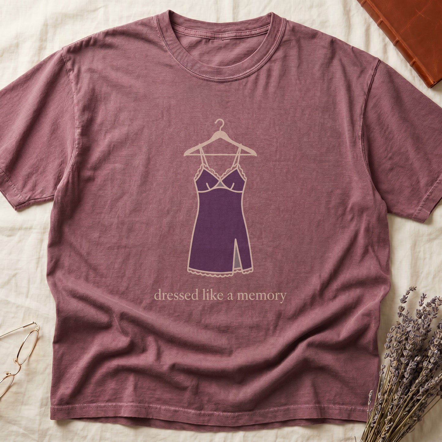 Dark Rose tee with dusty plum slip dress on cream hanger and "dressed like a memory" in lowercase cream serif below.
