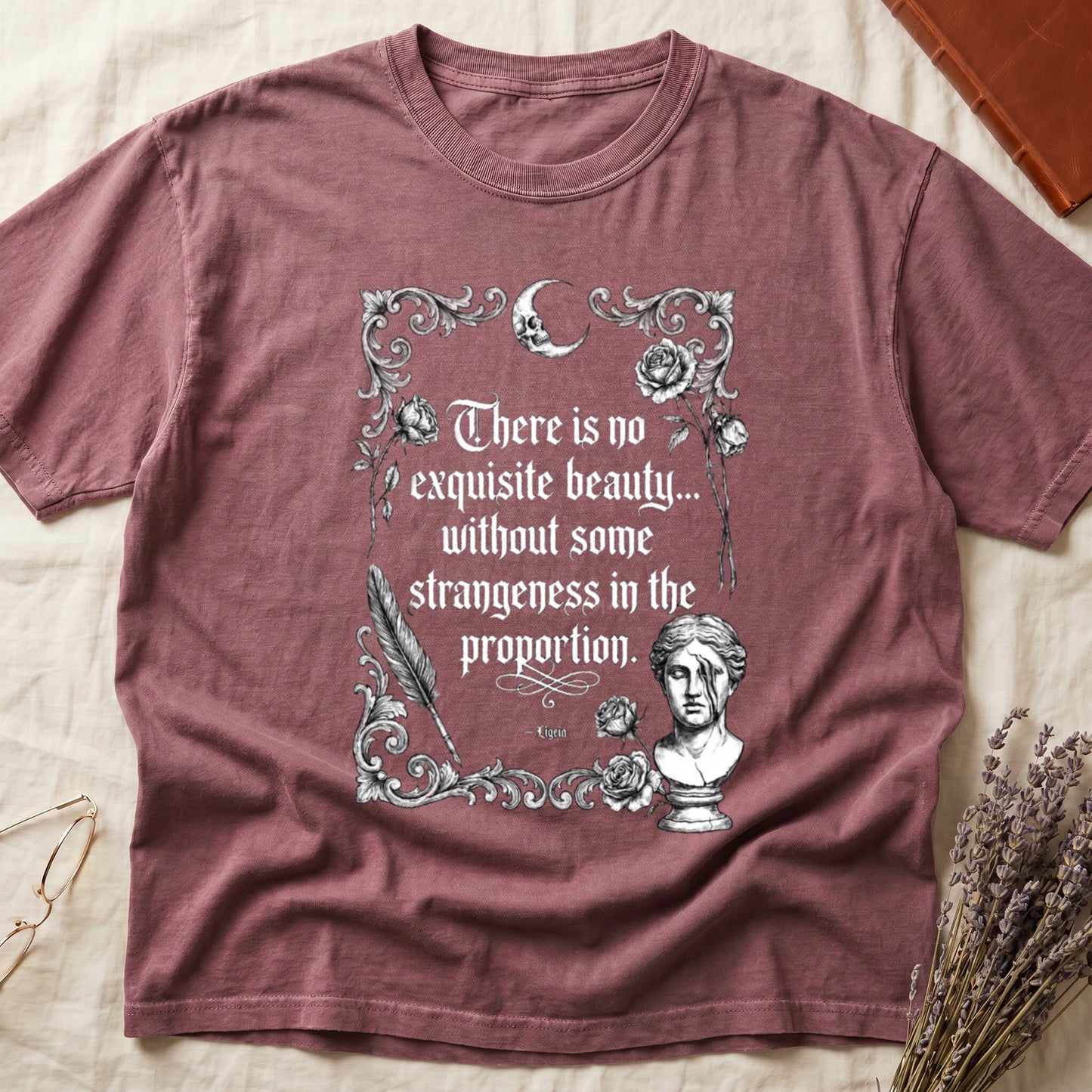 Rose-colored t-shirt with ornate text, moon, skull, feather, roses, and bust.