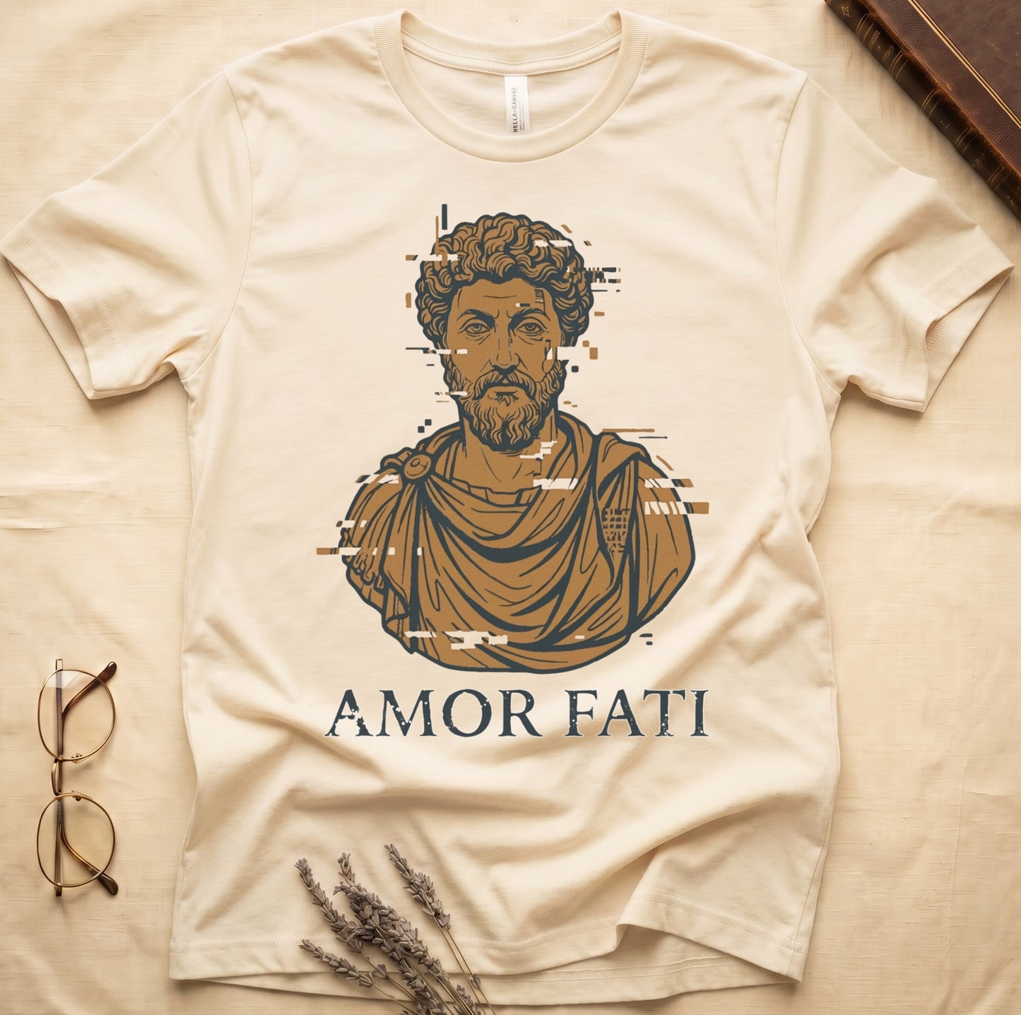 Natural tee with bearded Stoic bust portrait in copper and slate, "AMOR FATI" in distressed serif capitals below.