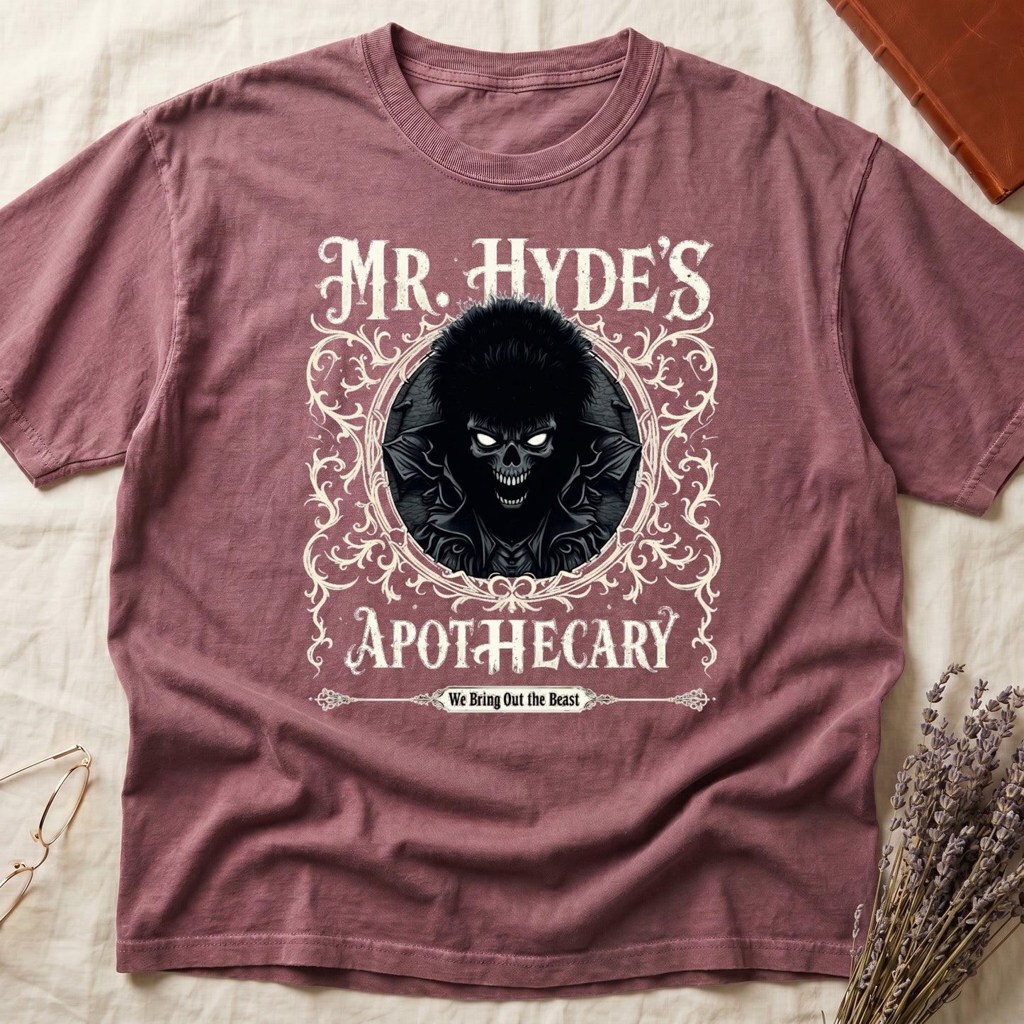 Blue Jean tee with ornate filigree frame, wild-haired skull figure, "MR. HYDE'S APOTECARY," "We Bring Out the Beast" below.
