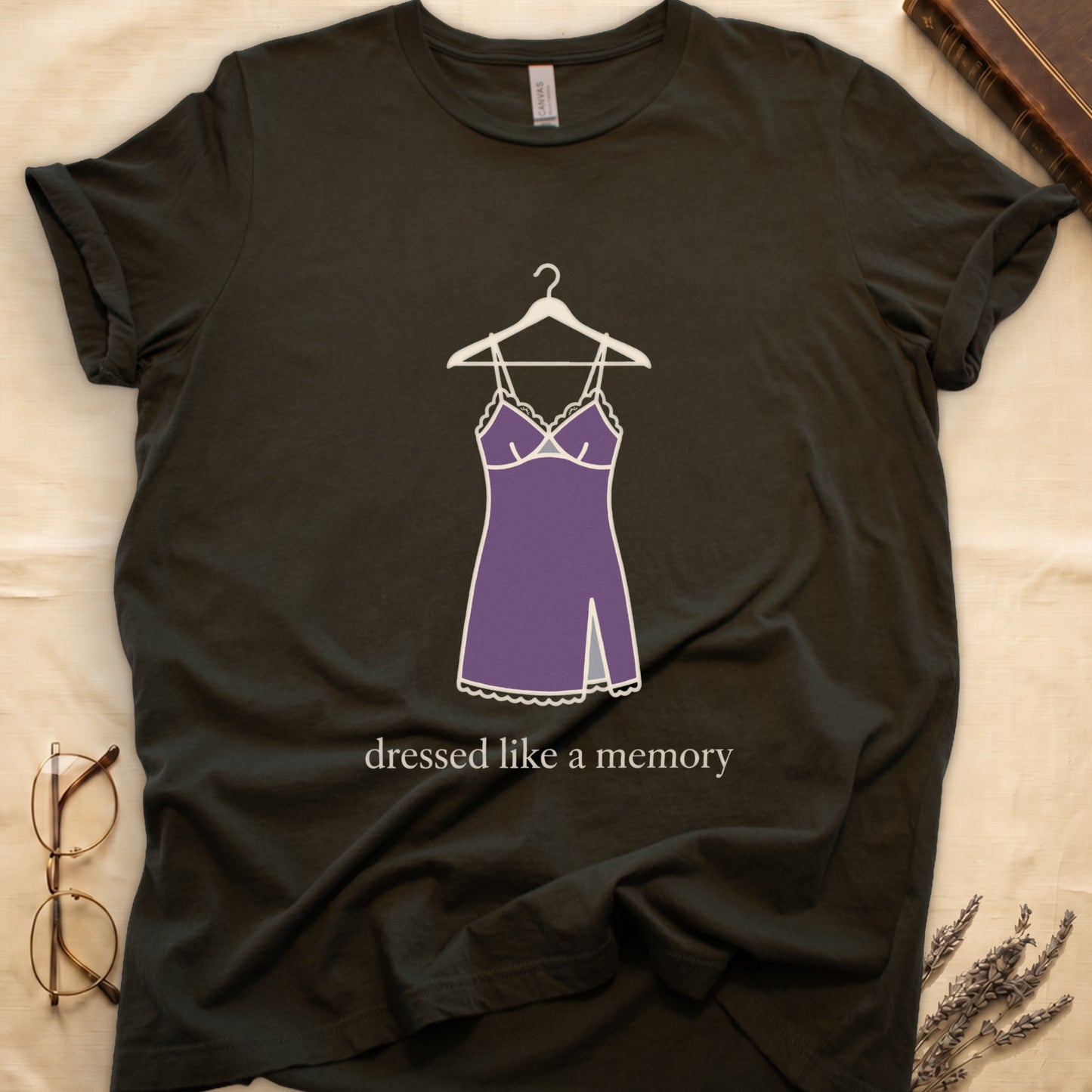 Military Green tee with dusty plum slip dress on cream hanger and "dressed like a memory" in lowercase cream serif below.