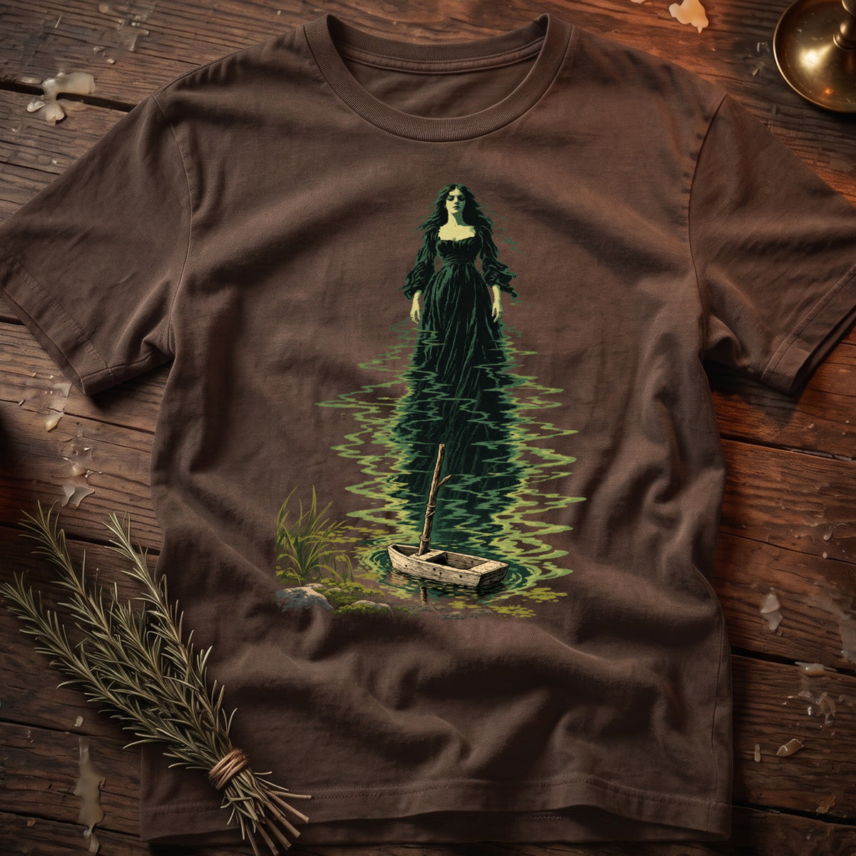 Brown t-shirt featuring a dark green illustration of a woman standing in water next to a boat.