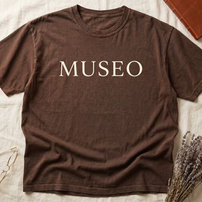 Espresso tee with "MUSEO" in oversized cream serif capitals, minimalist typographic design.