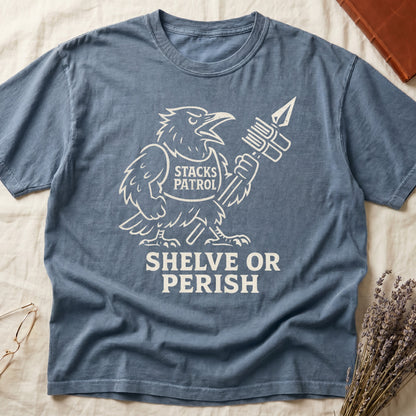 Blue Jean tee with vintage raven mascot, "STACKS PATROL" sash, feather pen aloft, "SHELVE OR PERISH" bold serif below.