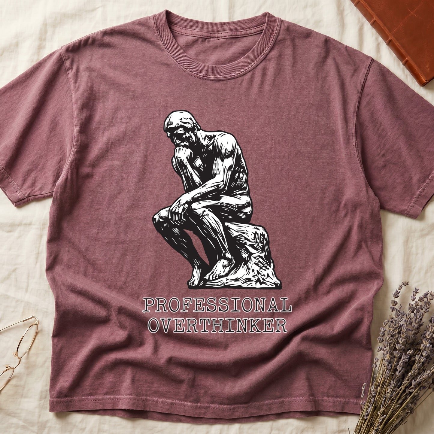 Dark Rose tee with monochrome rendering of Rodin's Thinker, "PROFESSIONAL OVERTHINKER" in serif capitals below.
