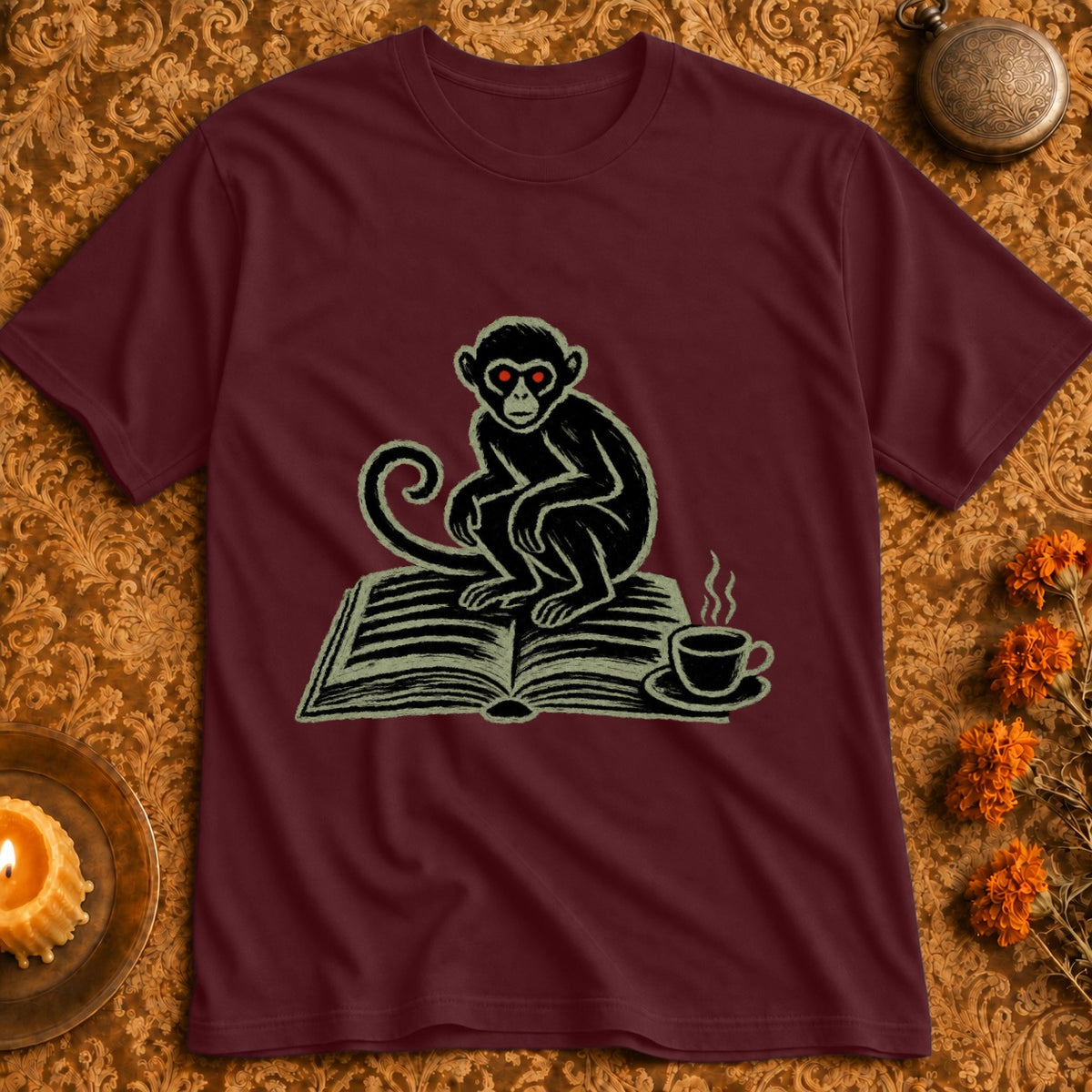 Maroon t-shirt with a drawing of a monkey reading a book and drinking coffee.